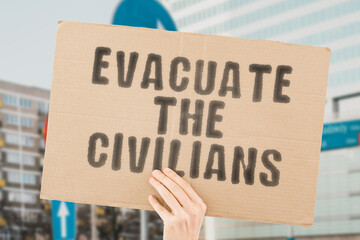 The phrase " Evacuate the Civilians " is on a banner in men's hands with blurred background. Event. Chaos. Foreigner. Emigrant. Fugitive. Force. Fight. Offense. Combat. Offensive. Disabled. Group
