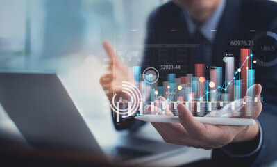 Businessman analyzing financial data, economic growth graph chart on digital tablet. Business...
