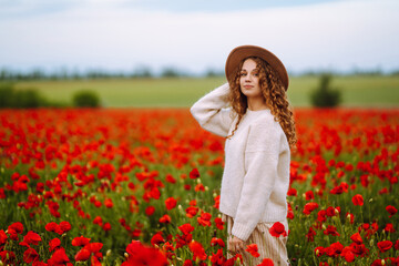 Beautiful woman in the blooming poppy field. Nature, vacation, relax and lifestyle. Summer landscape.