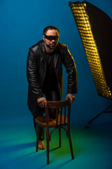 man in black leather clothes studio. fashionable handsome guy in leather with sunglasses. bearded...