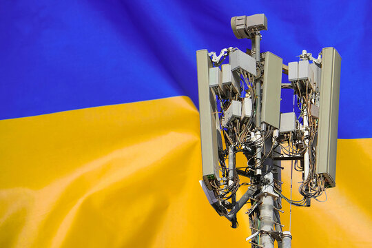 5G network antenna base station on background Ukraine flag. 6G network antenna base station on telecom tower emitting signal - Powered by Adobe