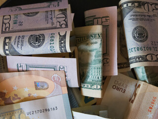 Cash banknotes dollars and euros are mixed up, a close-up shot.