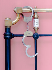 Shackles in bed headboard with pink wall
