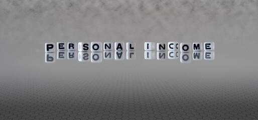 personal income word or concept represented by black and white letter cubes on a grey horizon background stretching to infinity