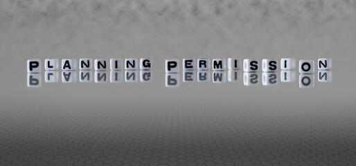 planning permission word or concept represented by black and white letter cubes on a grey horizon...