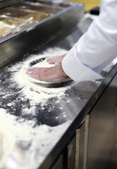 chef elaborando pizza con la masa