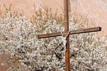Christian cross on a background of white flowers. Cross symbolizing the death and resurrection of...