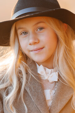 Close-up portrait of a beautiful girl in a hat on a warm bright autumn day