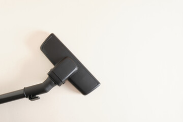 Head of modern vacuum cleaner on beige background. Close up.