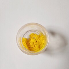 Yellow chemical powder in the clear plastic bottle with a gray background. Chemical precipitate silver phosphate. Chemical reaction on powder chemistry.