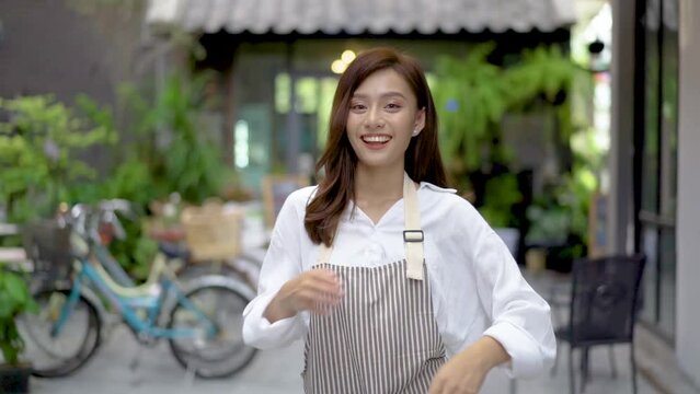 Successful small business young asian owner woman standing with looking at camera posing crossing arms, Portrait of waiter salesman worker wearing apron standing at work space smiling friendly