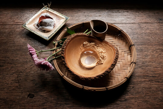 Selective focus. Japanese water cake or raindrop cake and Daifuku strawberry on wooden table. Japanese Dessert.