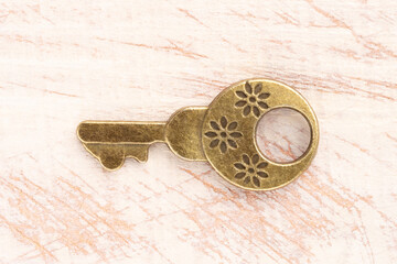 Bronze vintage antique key on brown wooden background. Old keys concept