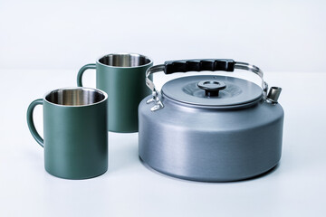 A tourist kettle and cups on grey background.