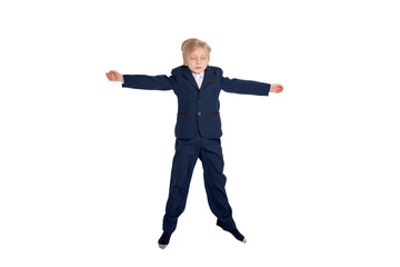 Boy from elementary school with closed eyes in school uniform holds his hands to the sides. Isolation on white background.
