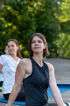 Portrait of young sports girl during a fitness workout in park outdoors. Yoga instructor.
