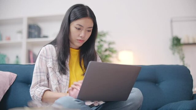 Asian woman getting virus on laptop, uncertified software, malicious program