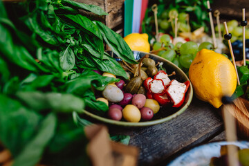 Italian cheese table decor for wedding or birthday. Flag of Italy, cheese, olives, lemons, grapes and ham.