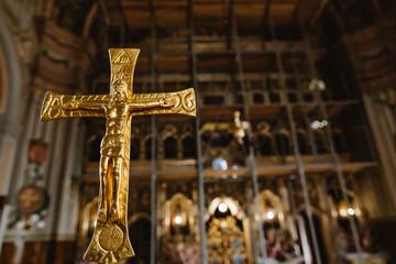 Golden cross on the background of the iconostasis in the Holy Church