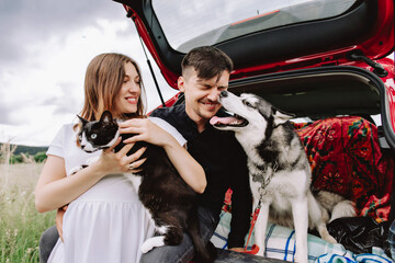 Family with animals in nature on the background of his car