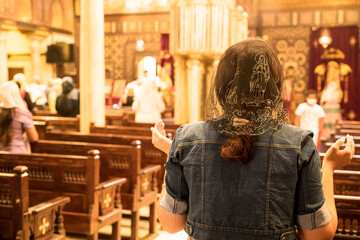 A lady praying and professing her religion inside a Church in Cairo. Photograph taken in the Coptic...