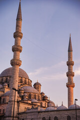 Blue Mosque in Instanbul Turkey during golden hour with almost purple sky in the background and the building in a pastel, painting like style. 