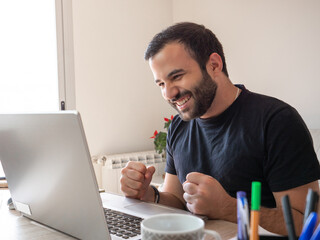Happy businessman working on laptop in home and enjoying his profist