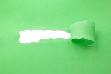 Hole in paper green color background damaged ripped