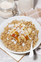 healthy breakfast quinoa with apple and coconut on white table, closeup
