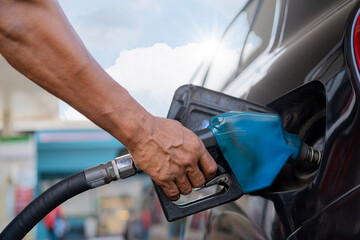 Refueling the car at a gas station fuel pump. Man driver hand refilling and pumping gasoline oil...