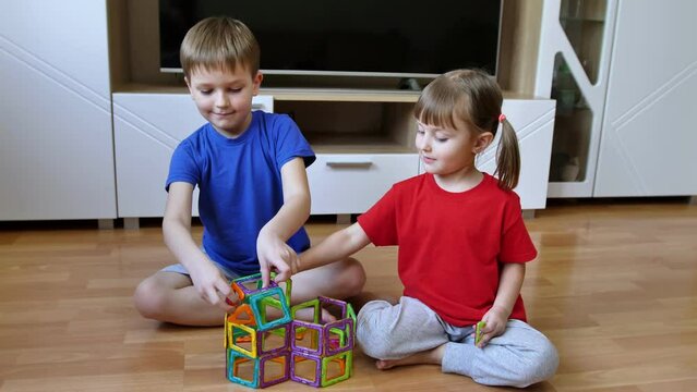Brother and sister are playing with a magnetic construction toy. Magnetic constructor for the development of motor skills