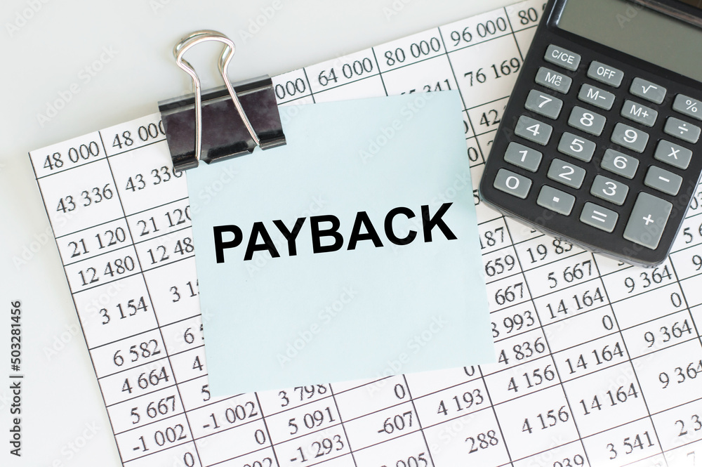 Poster text payback on a blue card clip to a sheet with a report and a calculator on the table