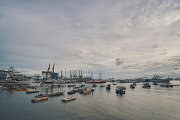 View of boats in the sea, with oil platforms in the background in singapore