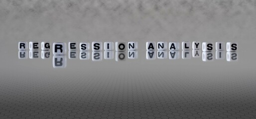 regression analysis word or concept represented by black and white letter cubes on a grey horizon...