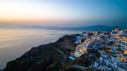The Famous greek iconic of sunset view tourist destination Oia village  in the night with traditional white houses and windmills in Santorini island , Greece