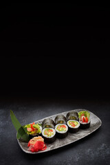 Sushi roll Yasai on a dark plate