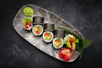 Sushi roll Yasai on a dark plate