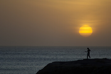 Man dancing at sunset in the coast of Dakar. Senegal.