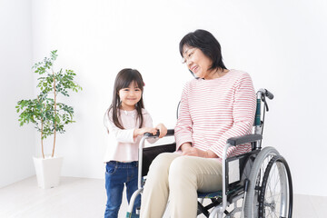 Fototapeta na wymiar 車椅子に乗るおばあちゃんと女の子
