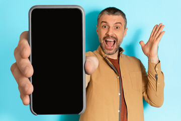 Excited Man Showing Blank Phone Screen Shouting Over Blue Background