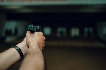 Professionals practice shooting a 9mm pistol inside a shooting range.