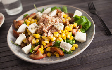 Fish salad with canned tuna and corn, tomatoes and arugula