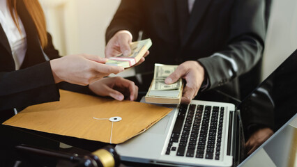 justice and law concept.passing bribe money in the envelop at office.