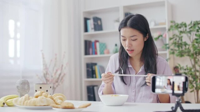 Korean woman blogger eating noodles for show, streaming video in social network
