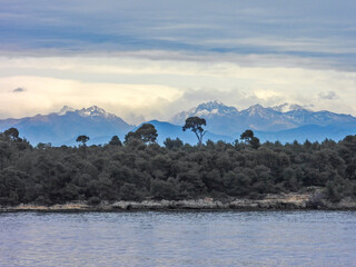 Obraz premium Paysage en bord de mer avec une forêt de pins et les sommets enneigés du Mercantour dans les Alpes du Sud en arrière plan