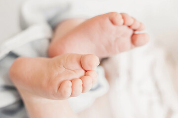 newborn baby legs top view. two baby feet on the background of white bed linen.