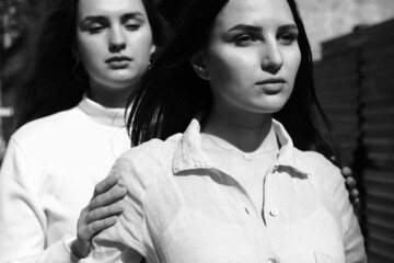 Black and white portrait of two girls. Girls in white dresses walking in the park