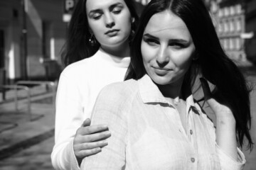 Black and white portrait of two girls. Girls in white dresses walking in the park