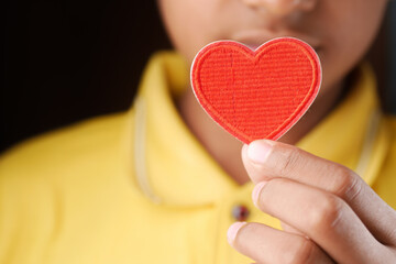  man hand in protective gloves holding red heart on blue 