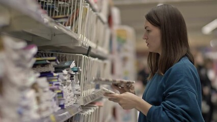 Young woman buys notebooks from the stationery department.